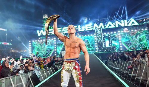 Cody Rhodes holds the WWE Undisputed Universal Championship belt over his head. He stands in front of the WrestleMania 40 entrance ramp.