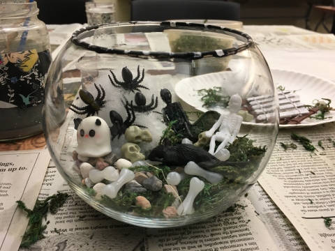 clear terrarium with spiderwebs, bones, and ghosts