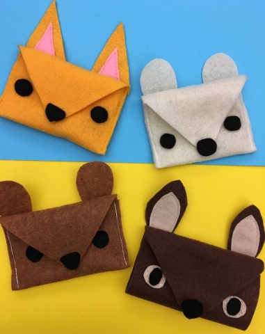 Four felt pouches: dark yellow fox, white polar bear, brown deer, and brown squirrel