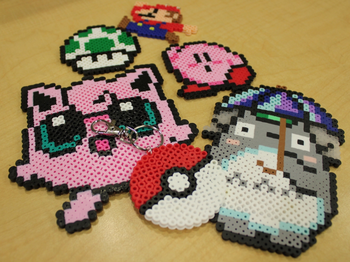 pixel art examples made out of perler beads: Jigglypuff, Totoro, Kirby, Mario, and a mushroom and poke ball