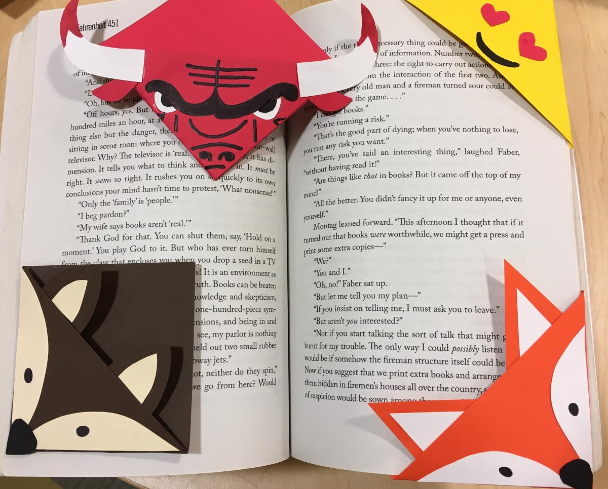 An opened book with Benny the Bull corner bookmark, Heart eyes emoiji corner bookmark, Orange fox corner bookmark, and Deer corner bookmark